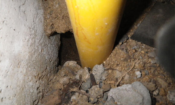 ネズミが掘った床下の配管周り